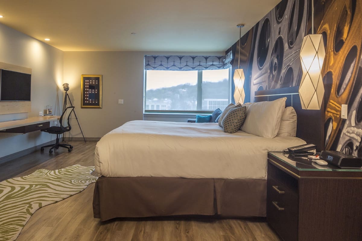 Une chambre d’hôtel moderne équipée d’un grand lit, d’un bureau, d’une chaise et d’une télévision.