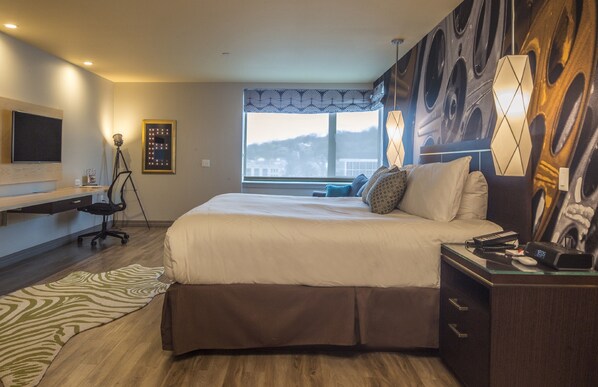 Een moderne hotelkamer met een groot bed, een bureau, een stoel en een televisie.