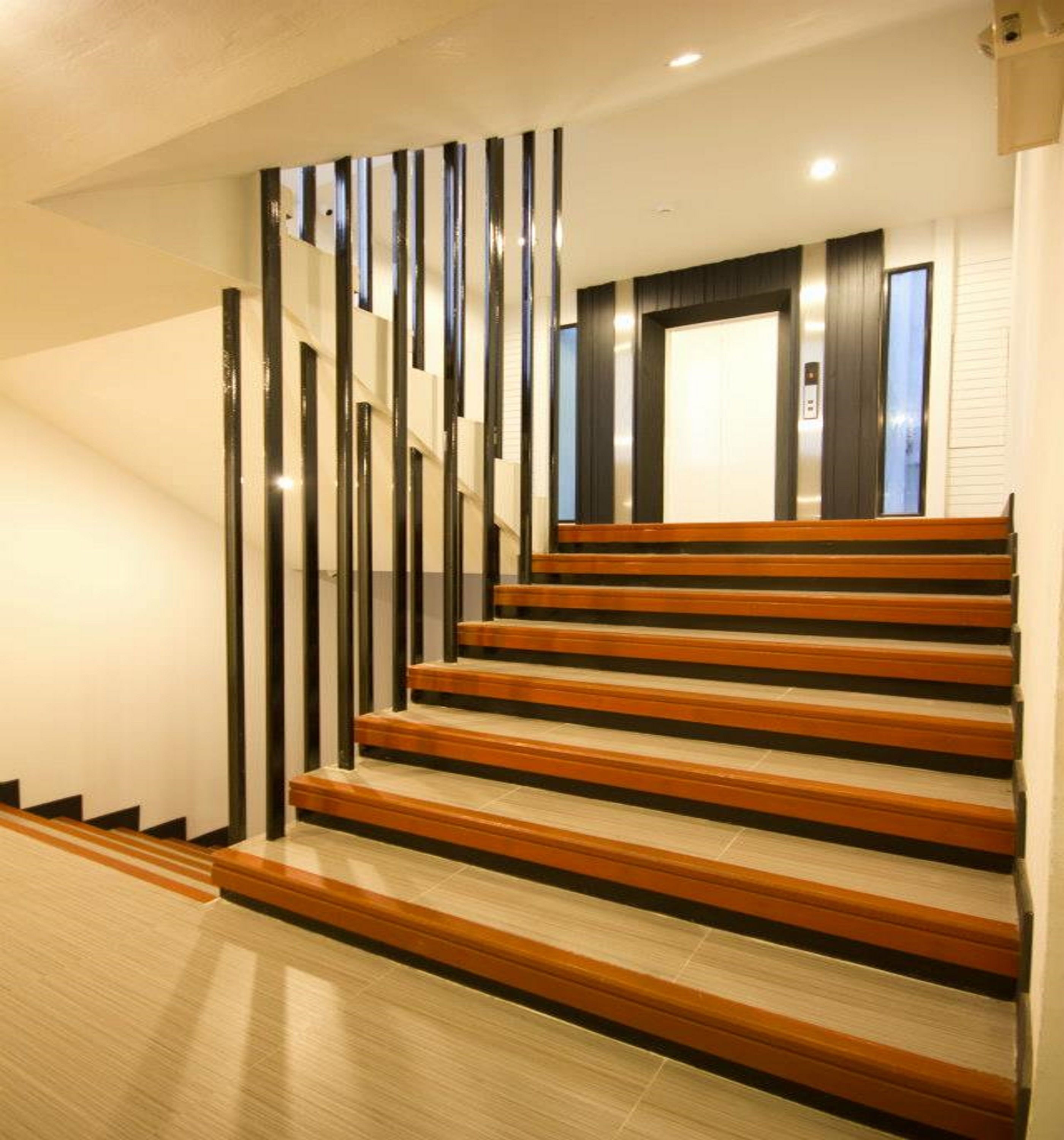 Una scala con gradini in legno e fasce verticali nere sulle pareti.