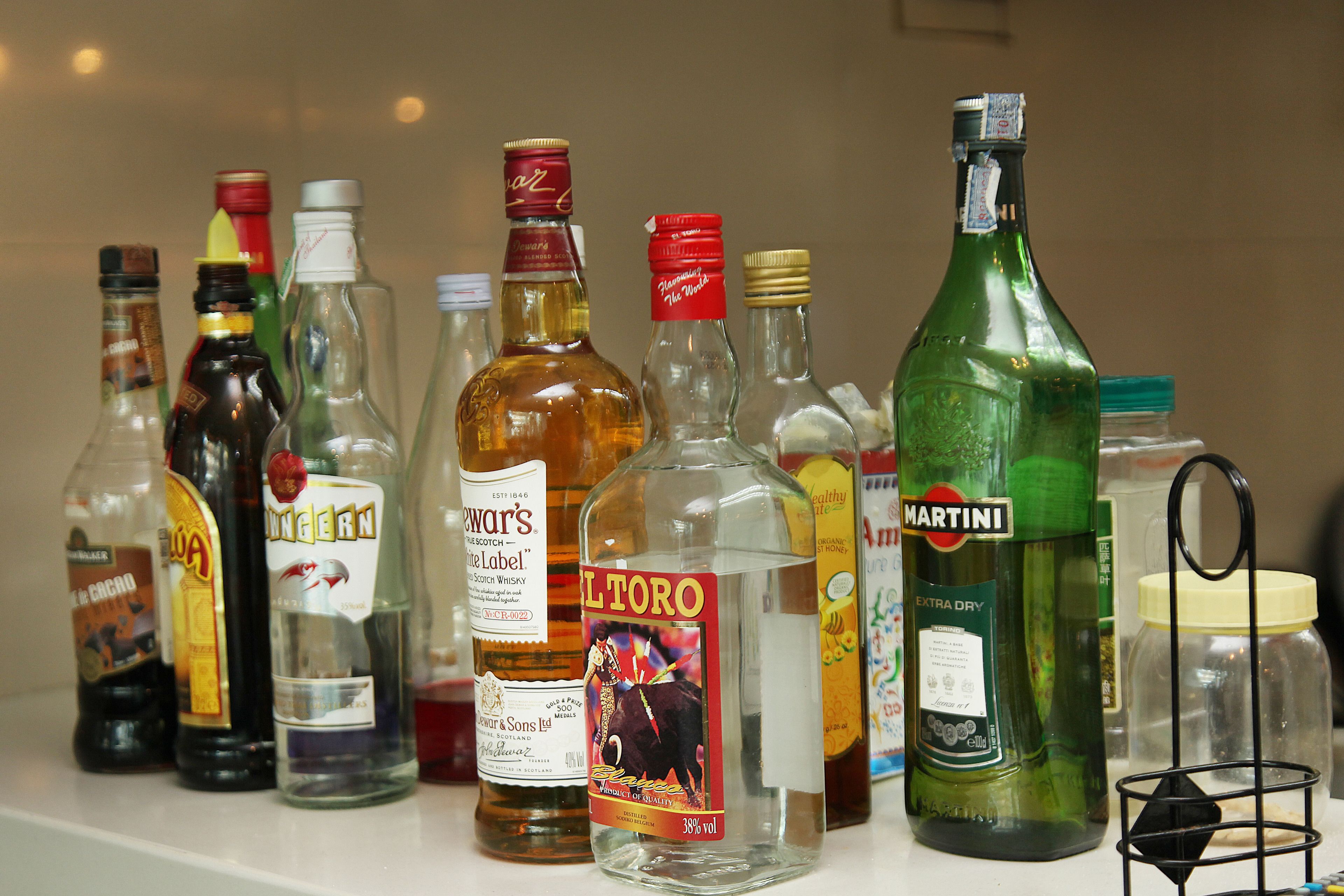 A variety of liquor bottles on a shelf.