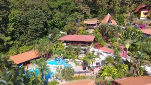 Un complexe hôtelier comprenant plusieurs bâtiments, une piscine et une végétation tropicale luxuriante.