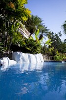 Una piscina al aire libre, sillones reclinables de piscina