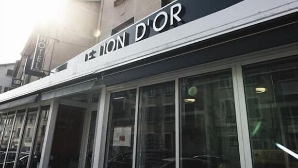 Een hotelgevel met het bord 'HOTEL D'OR' duidelijk zichtbaar.