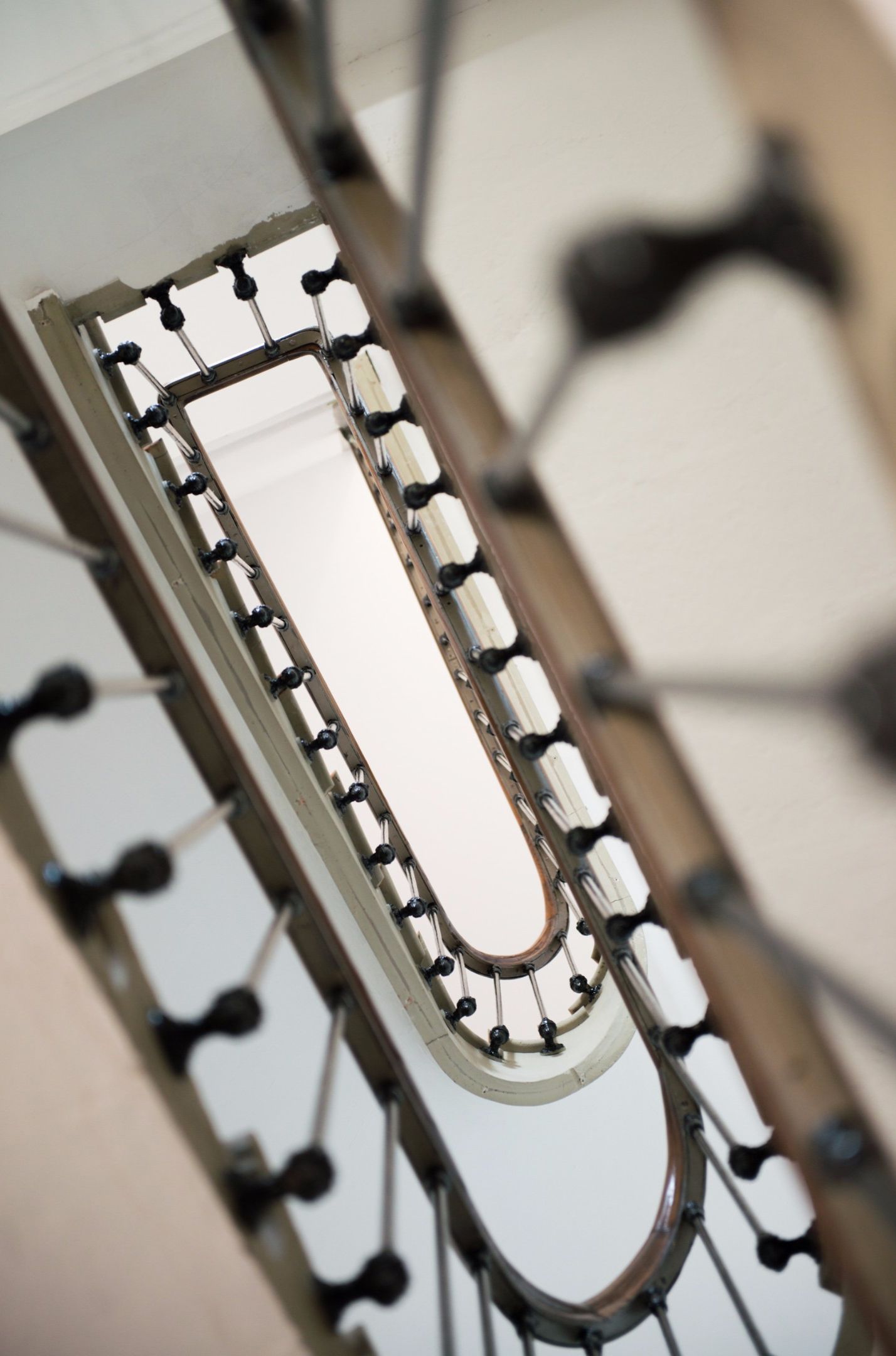 A close-up of a metal railing with a series of evenly spaced vertical bars and a curved top.