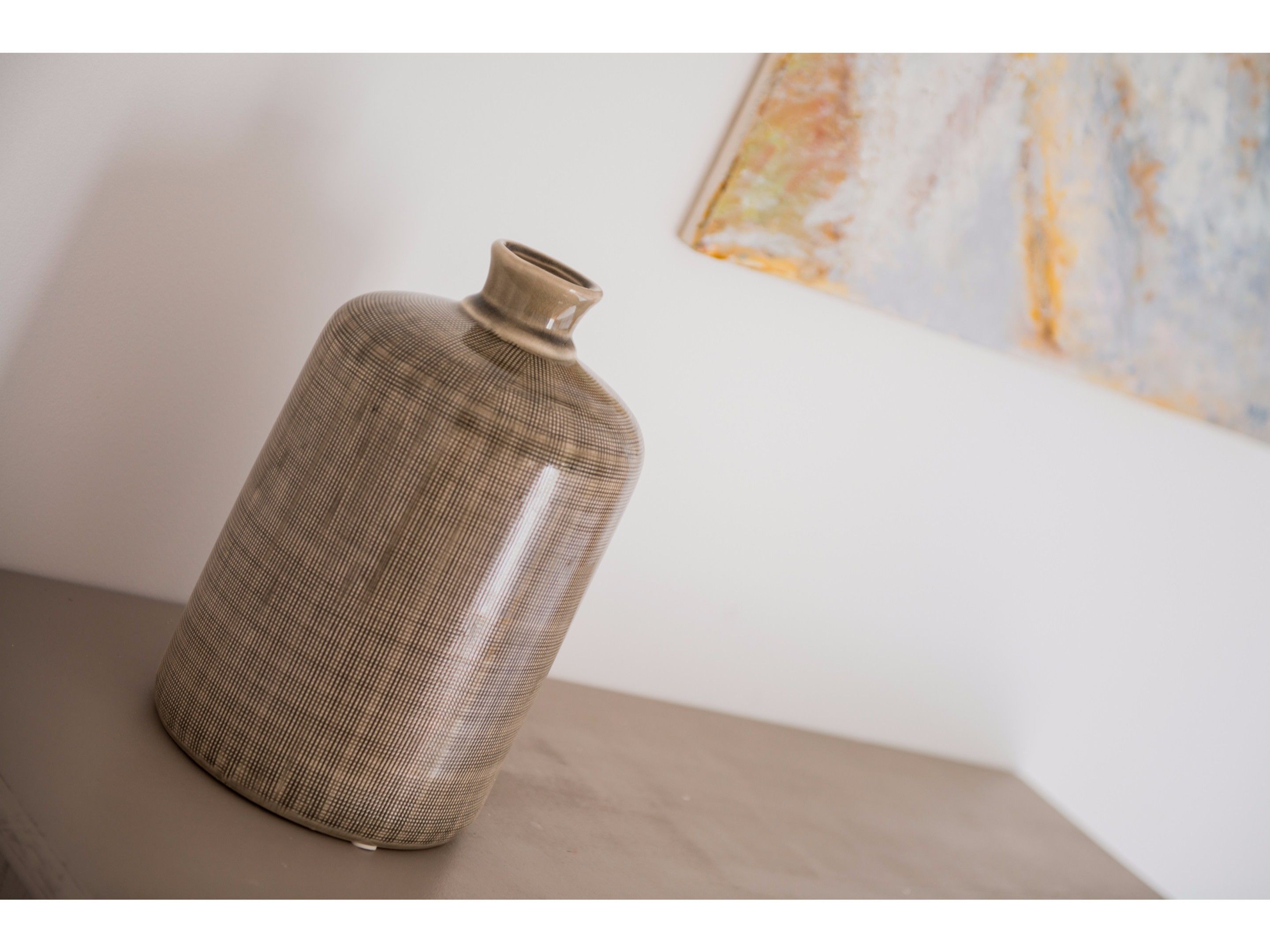 A ceramic vase with a ribbed texture on a wooden surface.