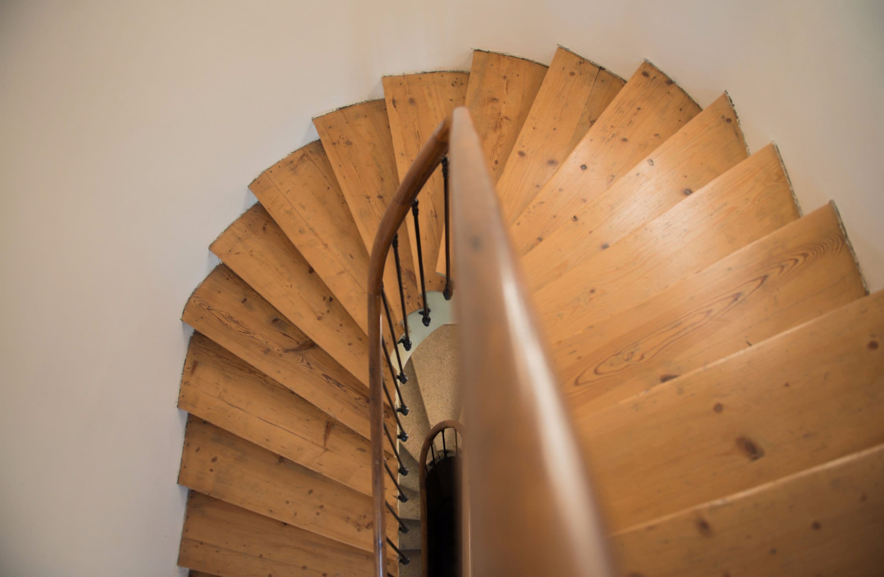 A spiral staircase with wooden steps and metal railings.