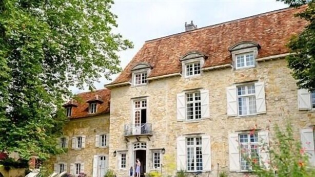 Ein Gebäude aus Stein mit vielen Fenstern und einem zentralen Eingang.