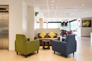 Eine Lobby mit Sitzgelegenheiten, einem Fernseher und einem großen Fenster.