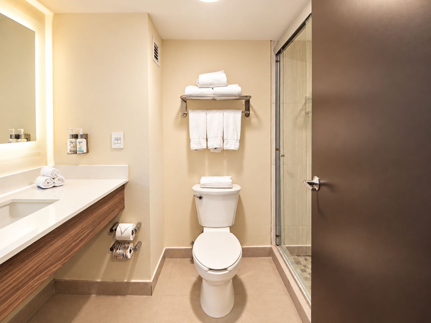 Un baño moderno con inodoro, lavamanos y zona de ducha.