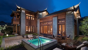 A traditional-style building with a swimming pool, outdoor seating, and a well-lit patio area. - Jinmao Purelax Lijiang -The Unbound Collection by Hyatt (Lijiang)