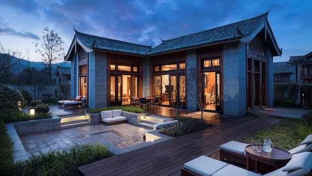 A modern house with a courtyard, outdoor seating, and a well-lit entrance. - Jinmao Purelax Lijiang -The Unbound Collection by Hyatt (Lijiang)