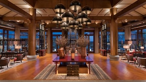 A spacious lobby with a central wooden table, large columns, and hanging pendant lights. - Jinmao Purelax Lijiang -The Unbound Collection by Hyatt (Lijiang)
