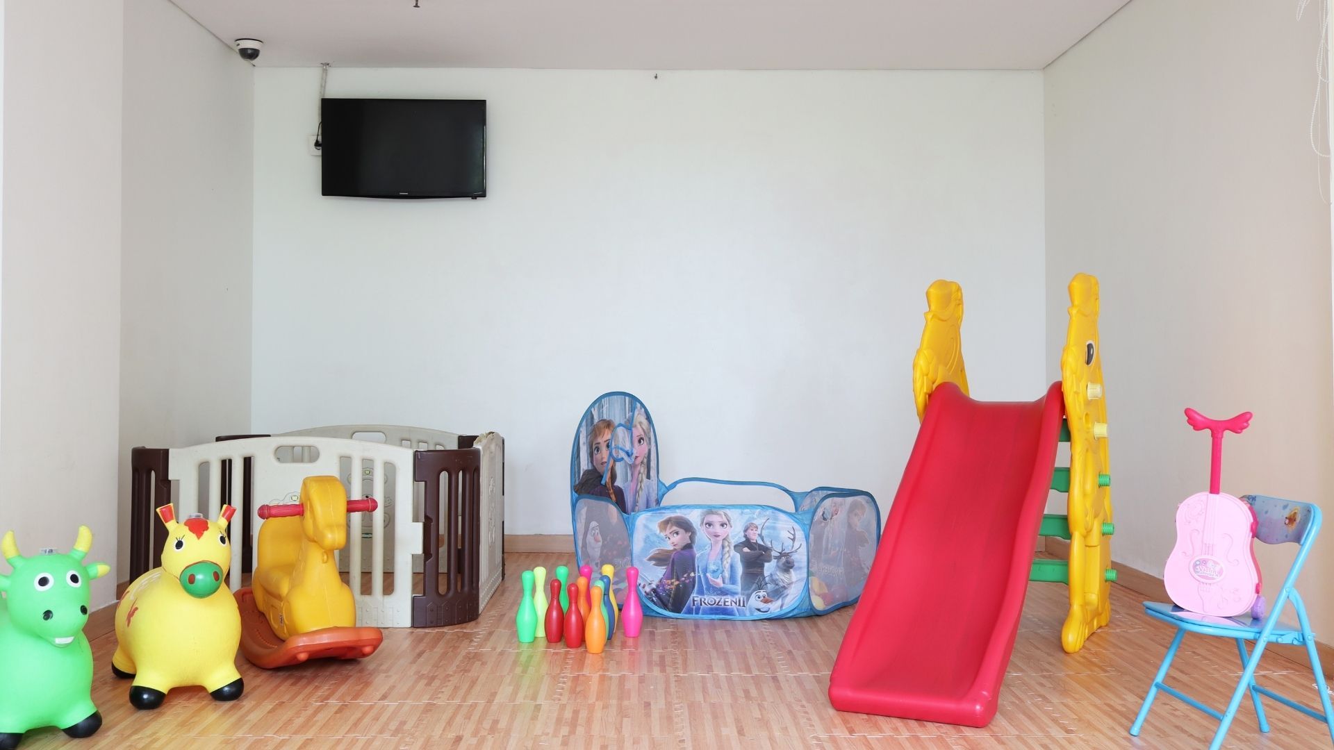 A children's play area with a slide, climbing structure, and various toys.