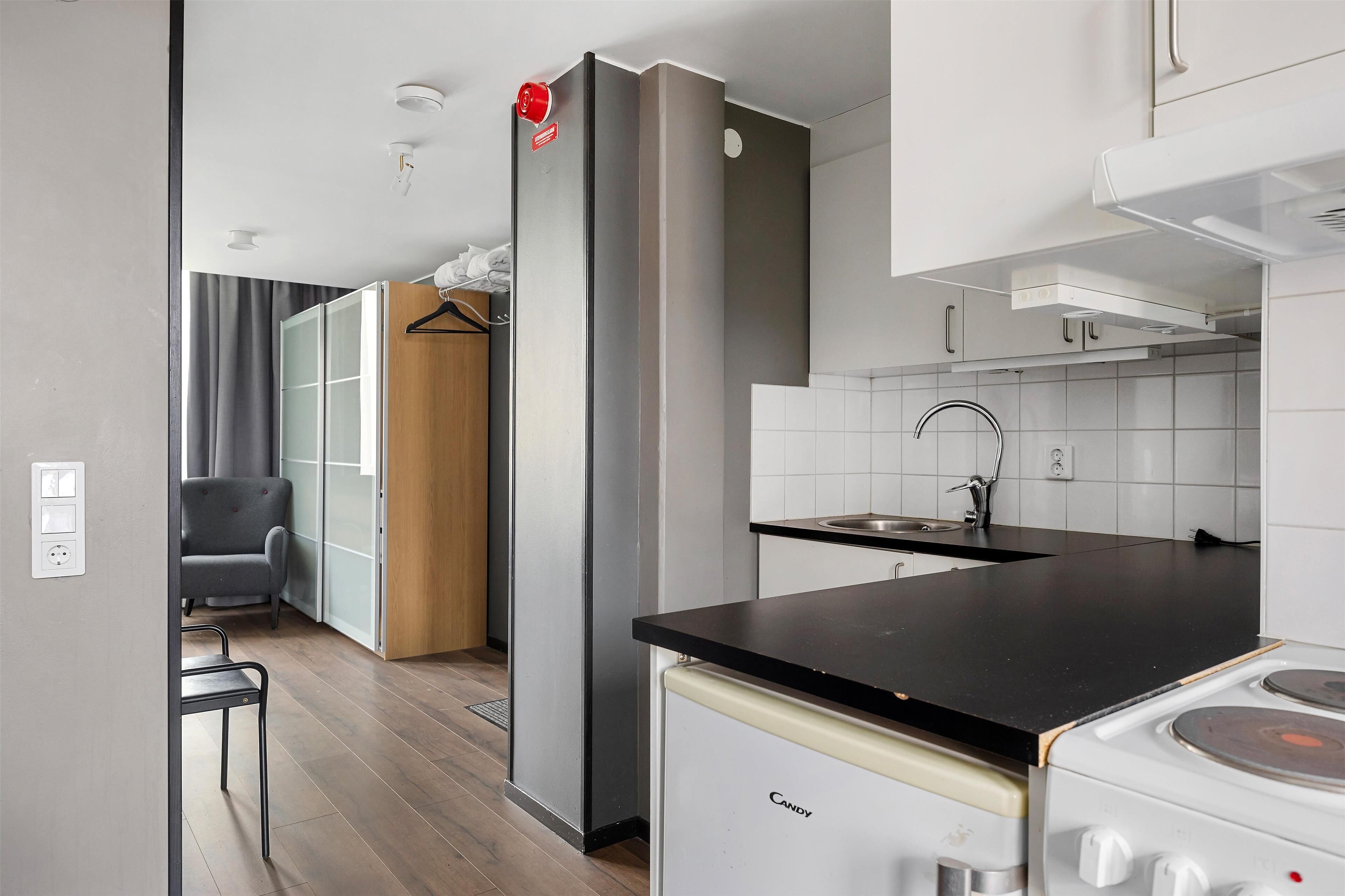 A compact kitchen with a stove, sink, and modern cabinetry.