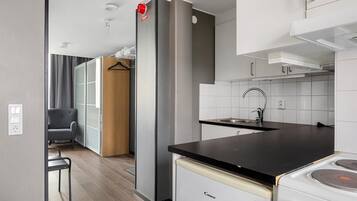 A compact kitchen with a stove, sink, and modern cabinetry.
