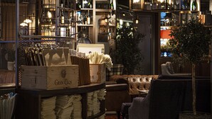A bar area with shelves of bottles, a leather couch, and a Christmas tree. - Best Western Hotel Norrkoping City (Norrköping)