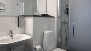 A bathroom with a sink, mirror, and shower.