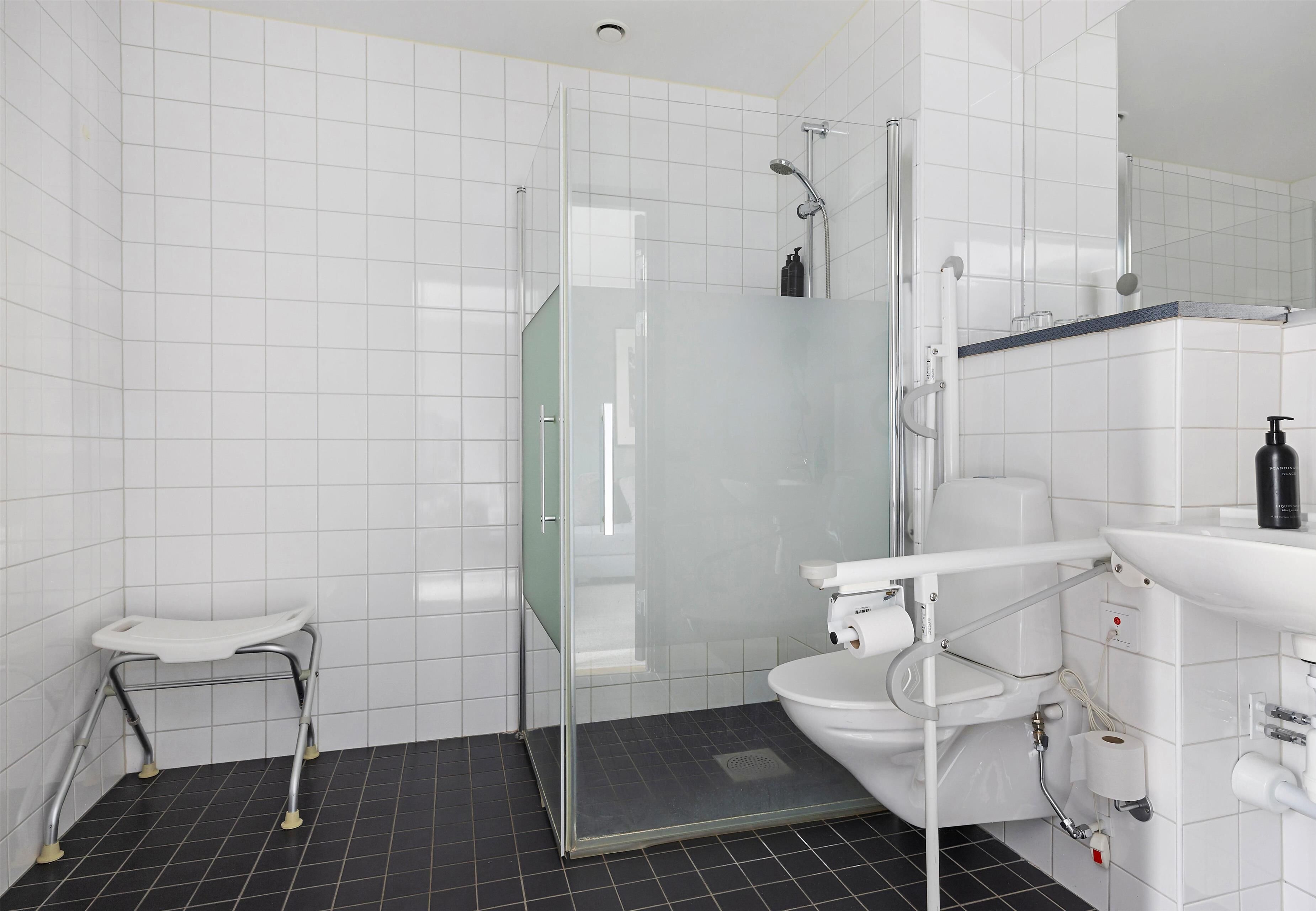 Un baño moderno con cabina de ducha de vidrio, inodoro y lavamanos blancos.