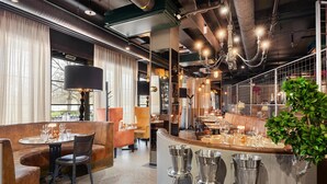 A restaurant with a bar area, seating with tables and chairs, and a large window with curtains. - Best Western Hotel Norrkoping City (Norrköping)