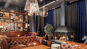 A cozy lounge area with leather sofas, a wooden table, and a fireplace. - Best Western Hotel Norrkoping City (Norrköping)