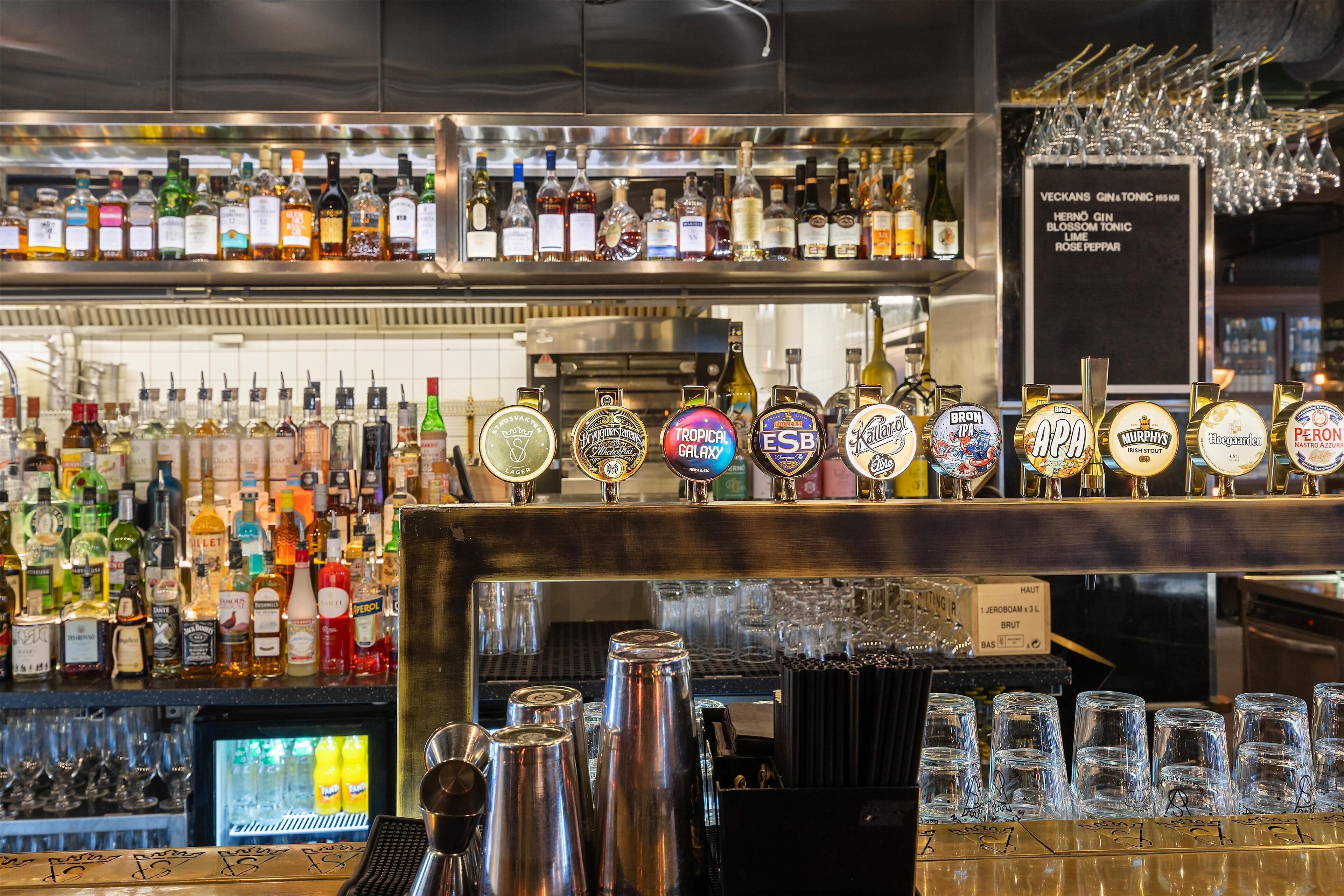 Un bar con varias botellas de licor y una selección de grifos de cerveza.