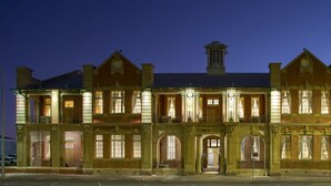 En stor, historisk bygning med flere etager, med buede vinduer og en central indgang, der er mærket "Technical College".