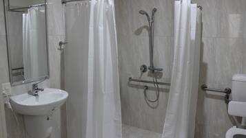 Une salle de bain moderne avec une douche à parois de verre, un lavabo blanc et des toilettes.