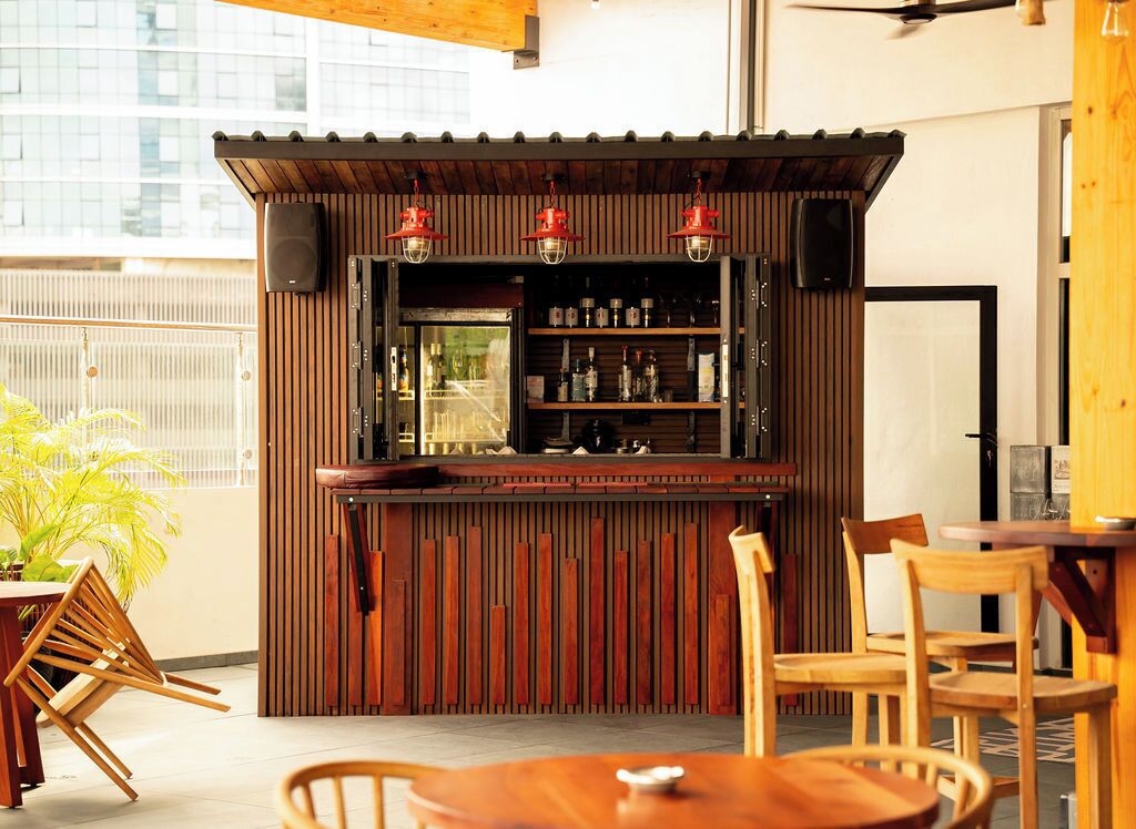 A bar area with wooden paneling and shelves stocked with bottles.