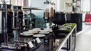 Montaje de bufé con varios recipientes de comida y fuentes de servicio.