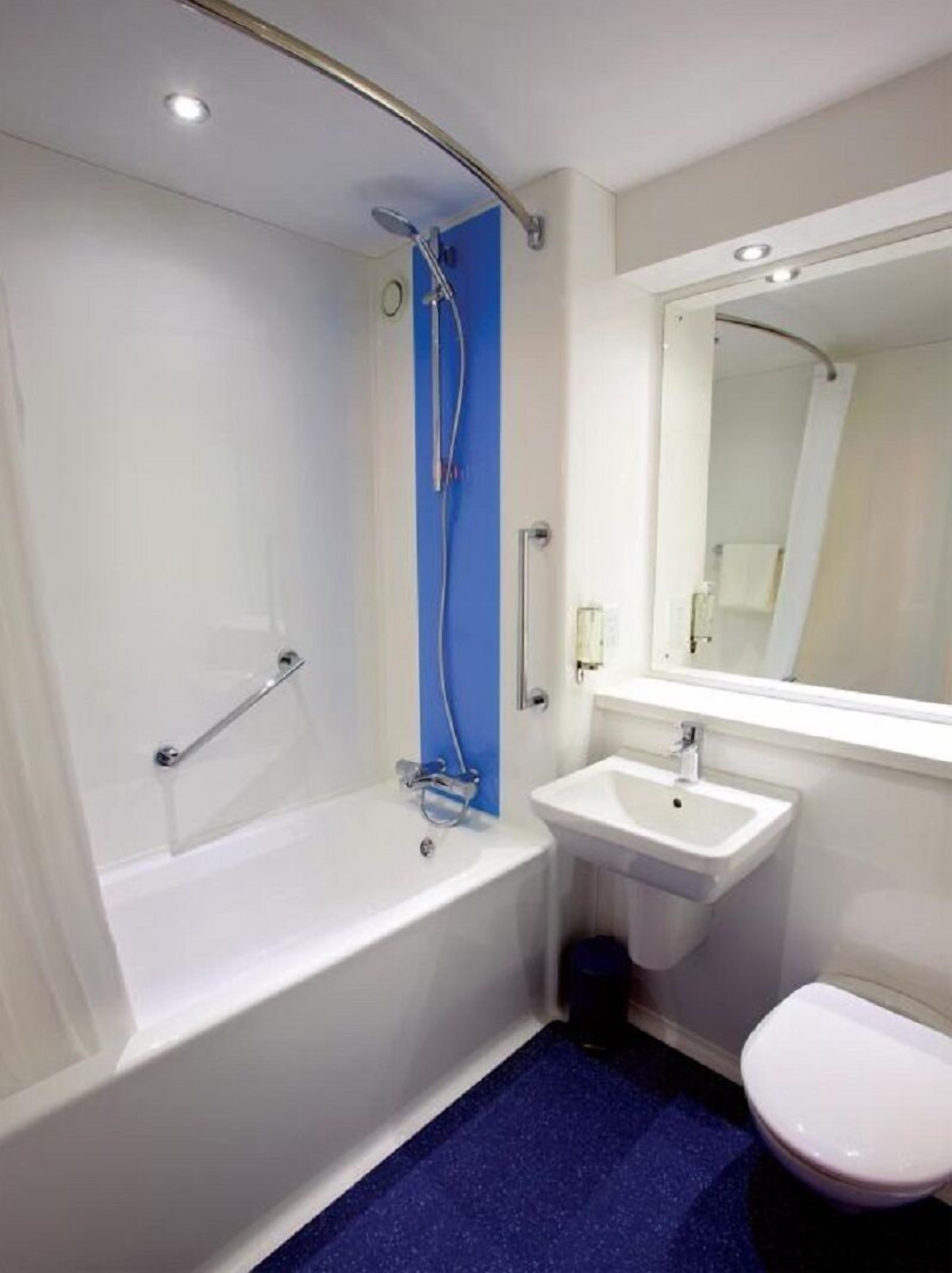 Un baño moderno con bañera, lavamanos e inodoro.