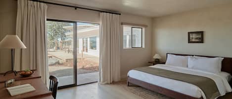 Een hotelkamer met een bed, bureau en uitzicht op de omgeving.