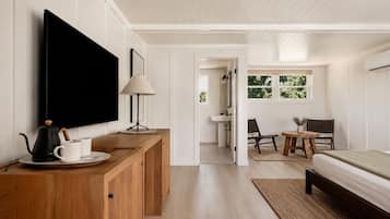 A modern bedroom with a TV, bedside table, and a bed.
