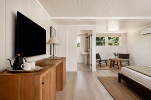 A modern bedroom with a TV, bedside table, and a bed. - The Herondale Hotel (Astoria)