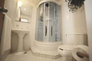 Een douche, handdoeken, zeep, shampoo