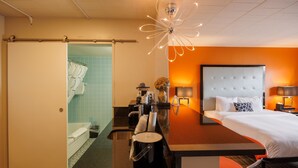 Een hotelkamer met een bed, een bureau, een douche en een badkamer.