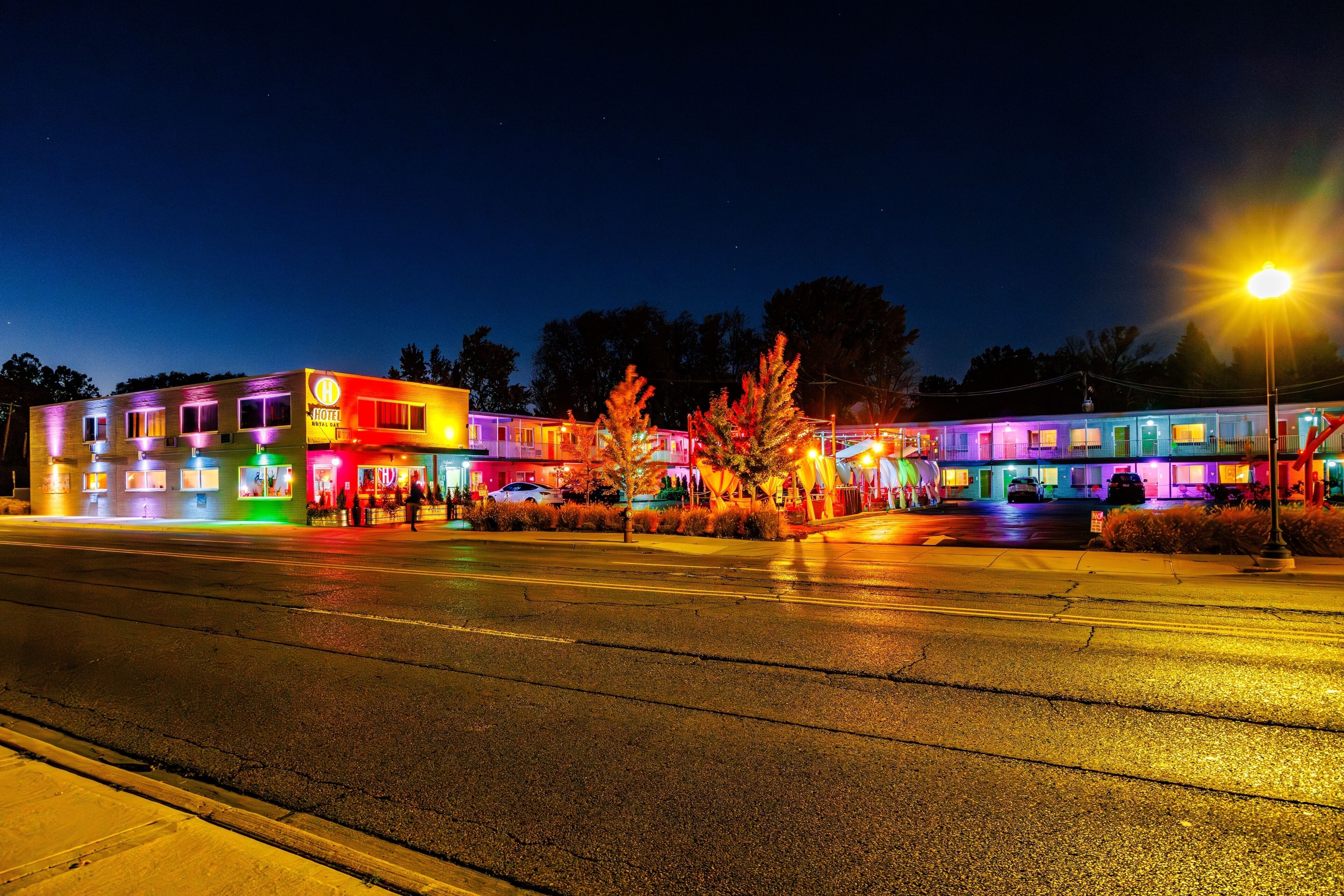 A brightly lit hotel with multiple floors and a visible sign indicating it is a hotel.