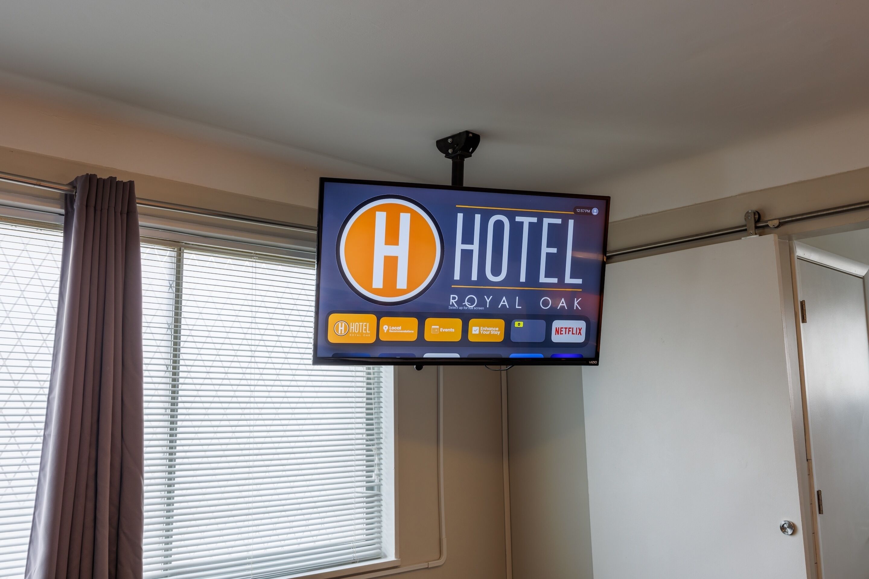 A hotel sign with the logo and name 'Royal Oak Hotel' and icons for amenities like hotel, location, events, and Netflix.