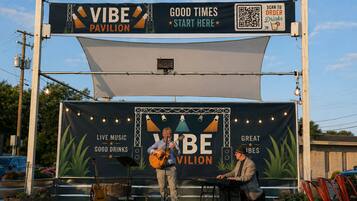 A live music stage with a banner advertising 'VIBE PAVILION' and 'GOOD TIMES START HERE'.