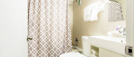 A bathroom with a toilet, sink, and shower curtain.