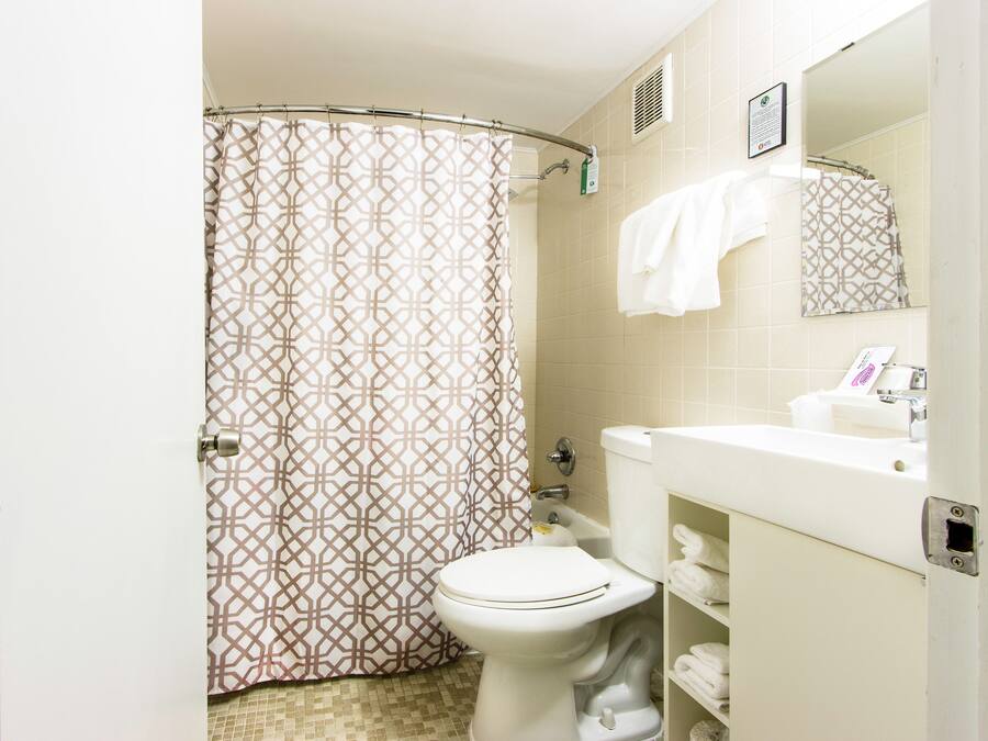 Een badkamer met toilet, wastafel en douchegordijn.