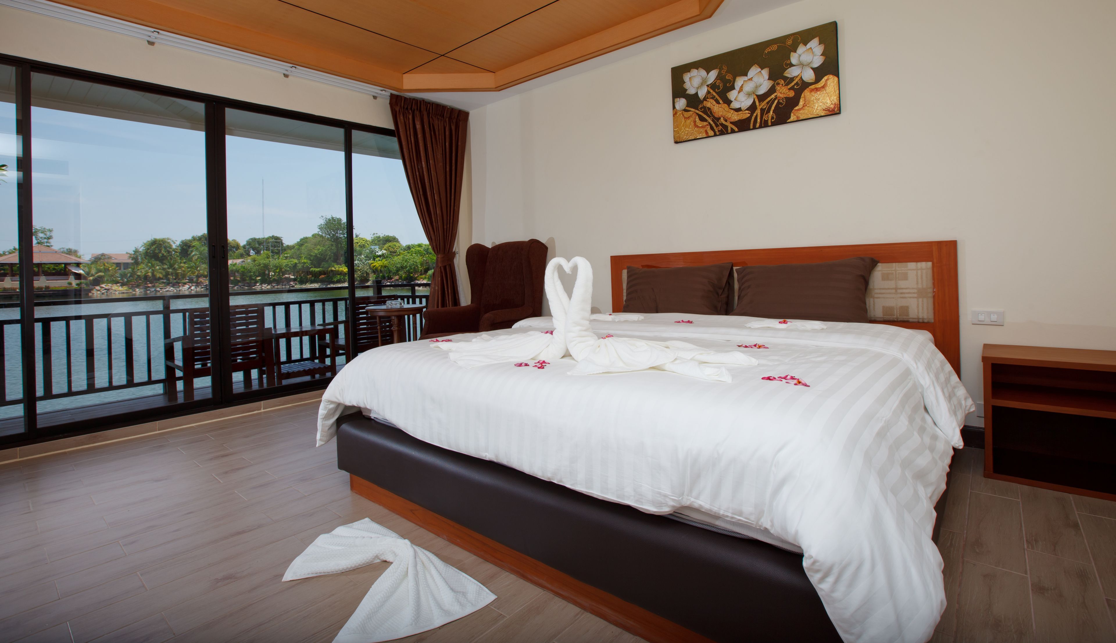 Una habitación de hotel con una cama grande, vistas al agua y un balcón.