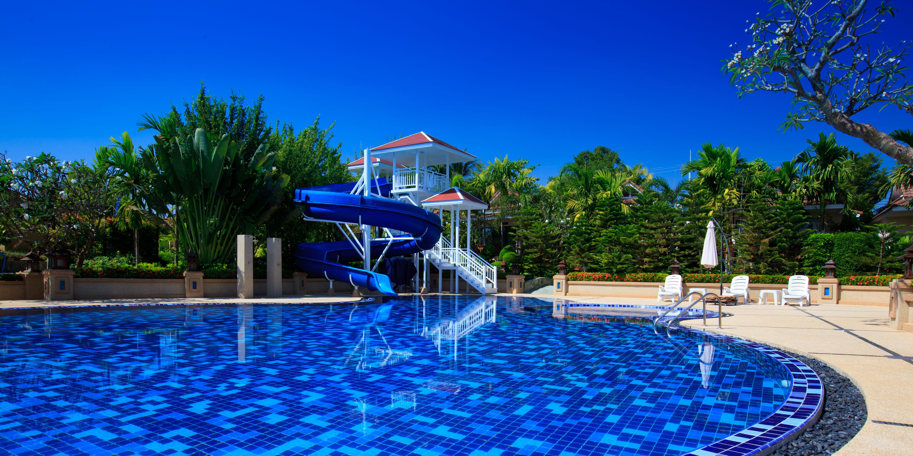 Una piscina con tobogán y una torre de salvavidas.