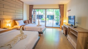 Ein Hotelzimmer mit zwei Betten, einem Fernseher und Blick ins Freie.