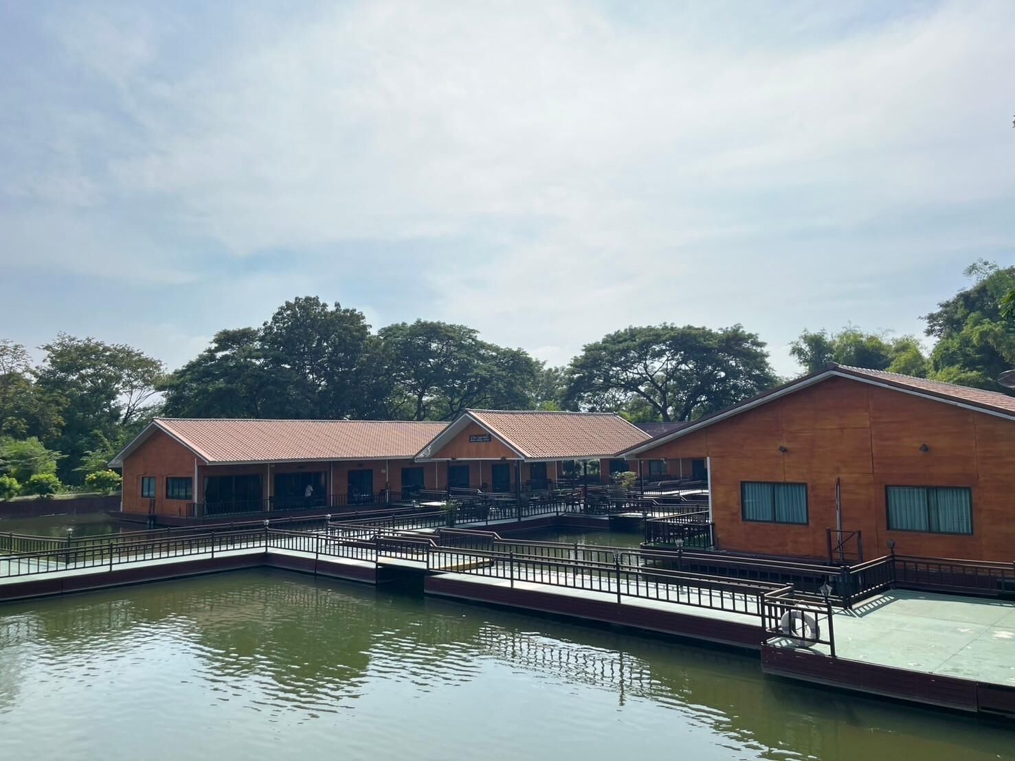 A waterfront hotel with multiple buildings, a dock, and a calm water body.
