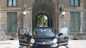 A black Fiat car parked in front of a building with green shutters and a stone facade. - Hotel Barbarella (Giugliano in Campania)
