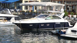 A marina with boats docked, a restaurant named "LA SCIALUPPA" with outdoor seating, and a building with a sign reading "HOTEL". - Hotel Barbarella (Giugliano in Campania)