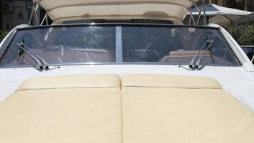 A convertible car with a soft top, beige interior, and a sunroof.
