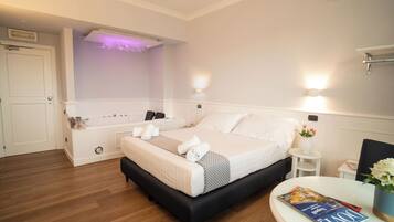 Een verzorgde hotelkamer met een bed, nachtkastjes, een klein tafeltje met een tijdschrift, en een wandairconditioner.