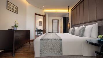 Habitación de hotel moderna con una cama grande, un aparador de madera oscura, un escritorio con una silla y vistas al pasillo.