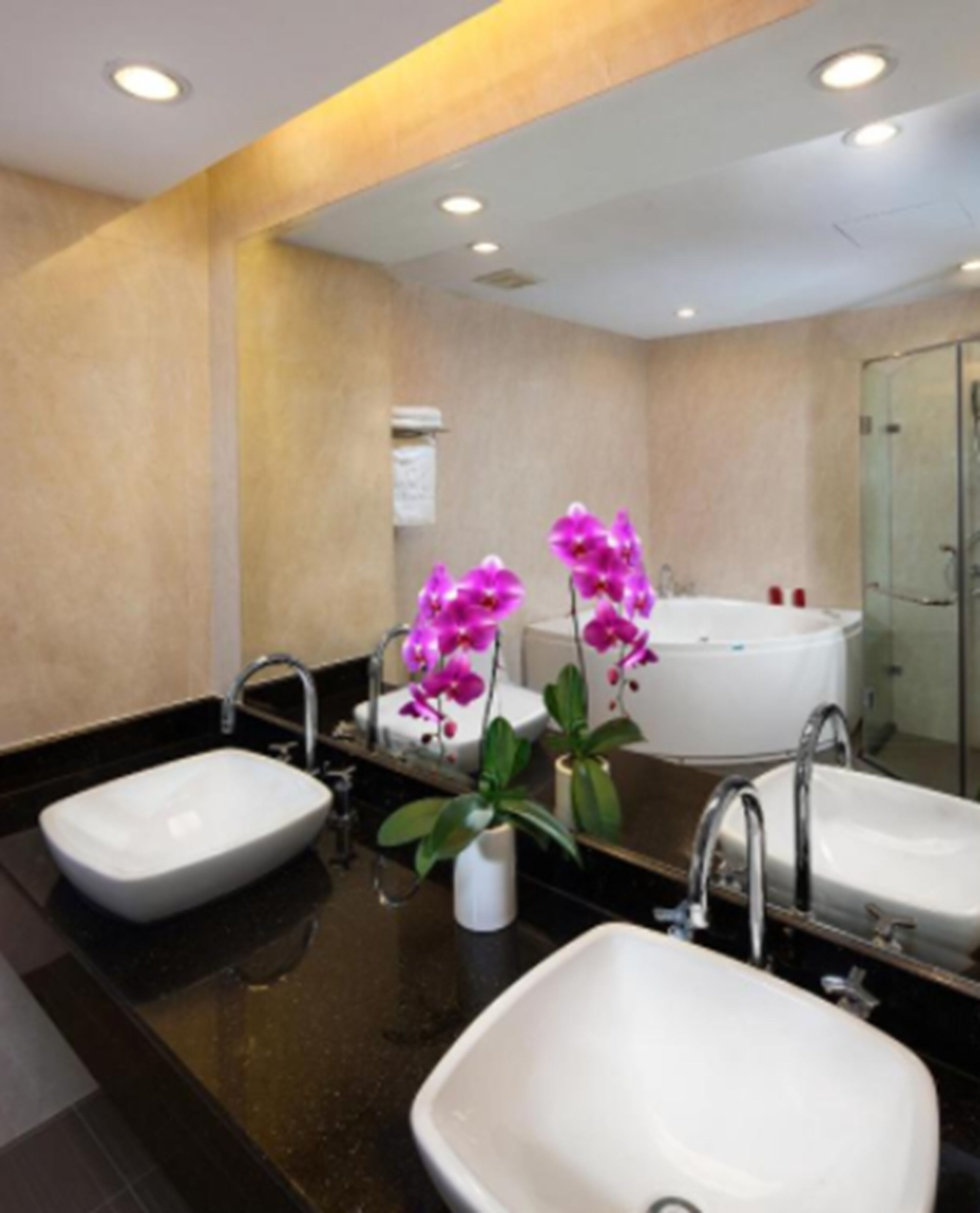 A modern bathroom with two sinks, a bathtub, and a shower.
